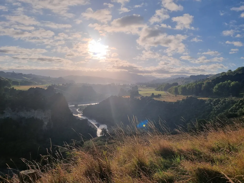 A colour image of a landscape over the Rangitīkei River with the sun in the background