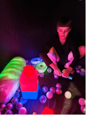 Carter enjoying the blackout tent with some of the visual lighting toys