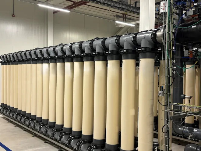 A photo of cream coloured cylindrical containers standing horizontal on a concrete floor. They have membranes in them that remove unwanted minerals from water.