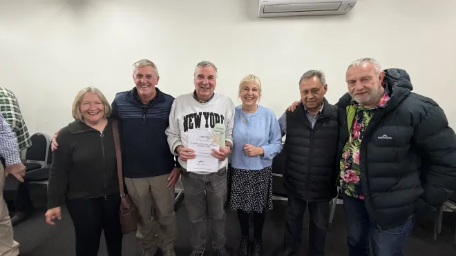 Gary is stood in teh middle of a group photo, with friends and family either side of him.